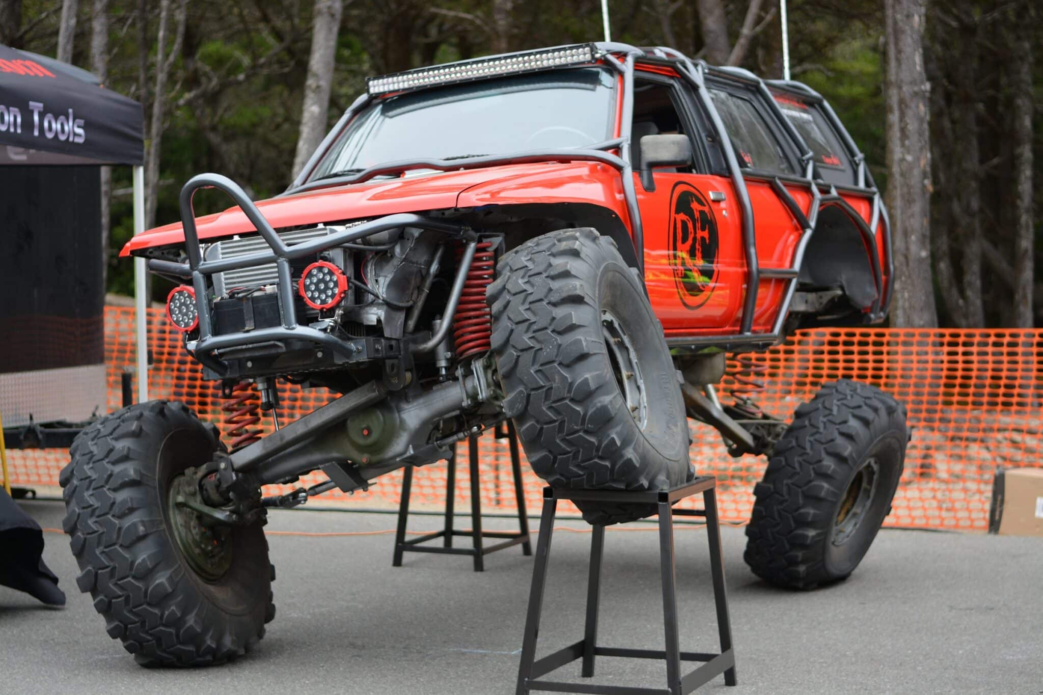 1988 Toyota 4Runner on display stands showing Unimog 404 portal axles, coilover suspension, and fabricated tube front bumper