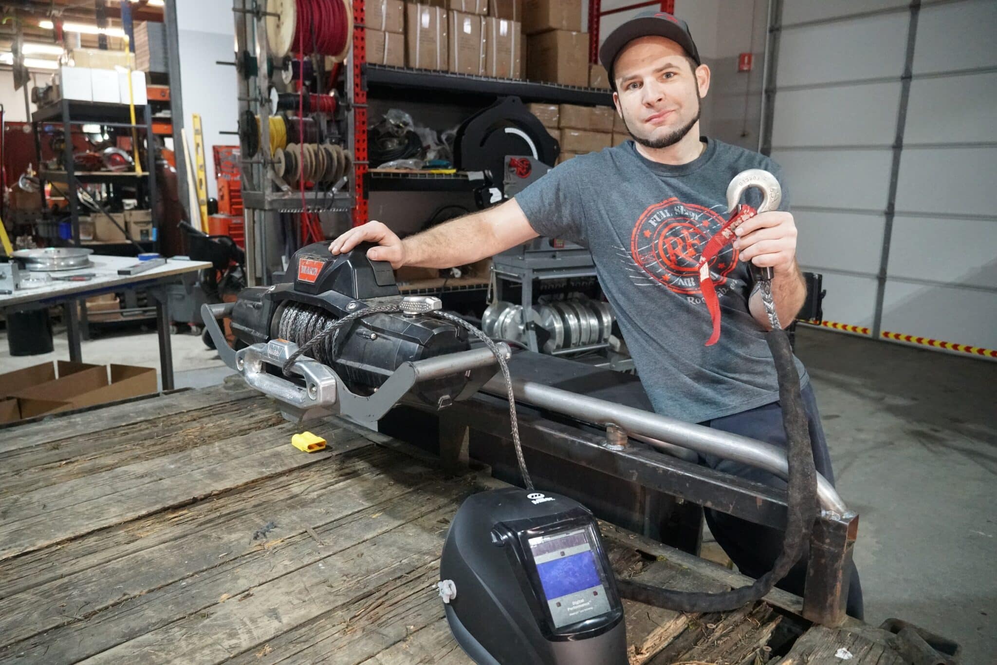 Joe Gambino in the Rogue Fabrication shop in Sandy Oregon with a fabricated tube front bumper and Warn winch in the foreground