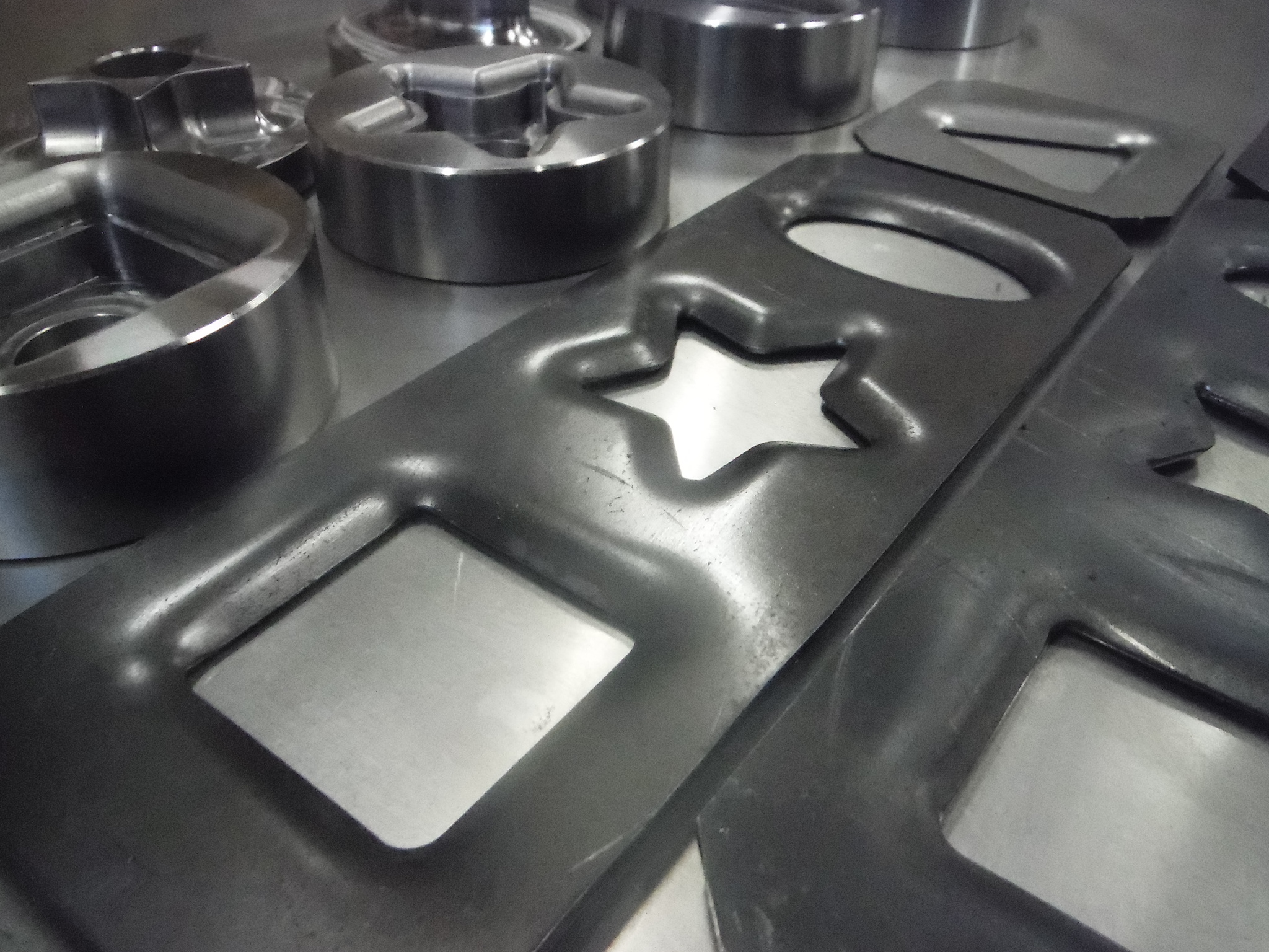 Shaped dimple dies — star, square, and oval — machined, heat-treated, and nickel-plated in Oregon by Rogue Fabrication