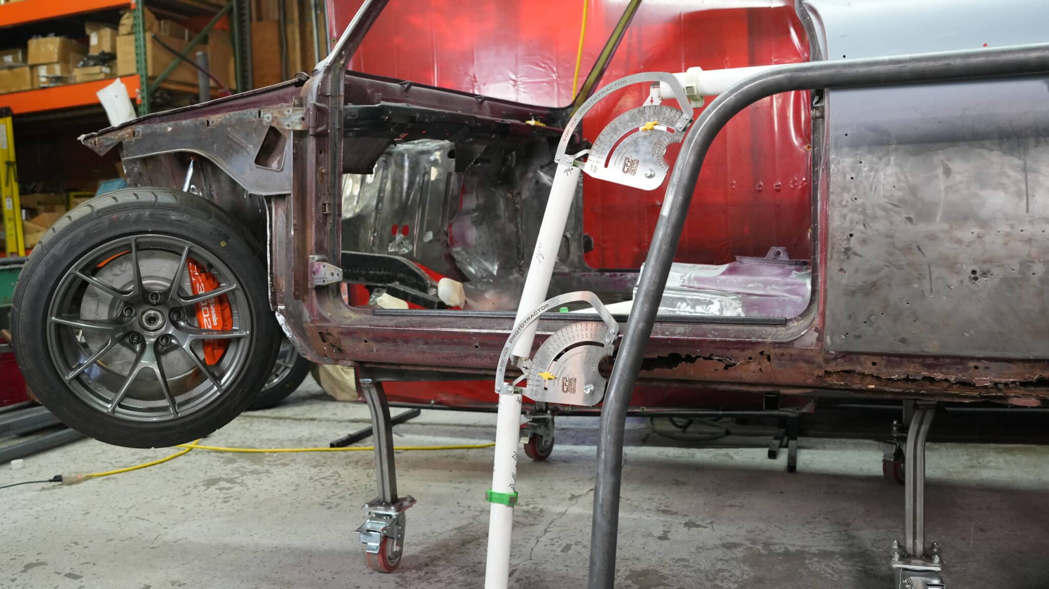 Prototractor tube bending layout tool in use on a roll cage build inside a stripped car body