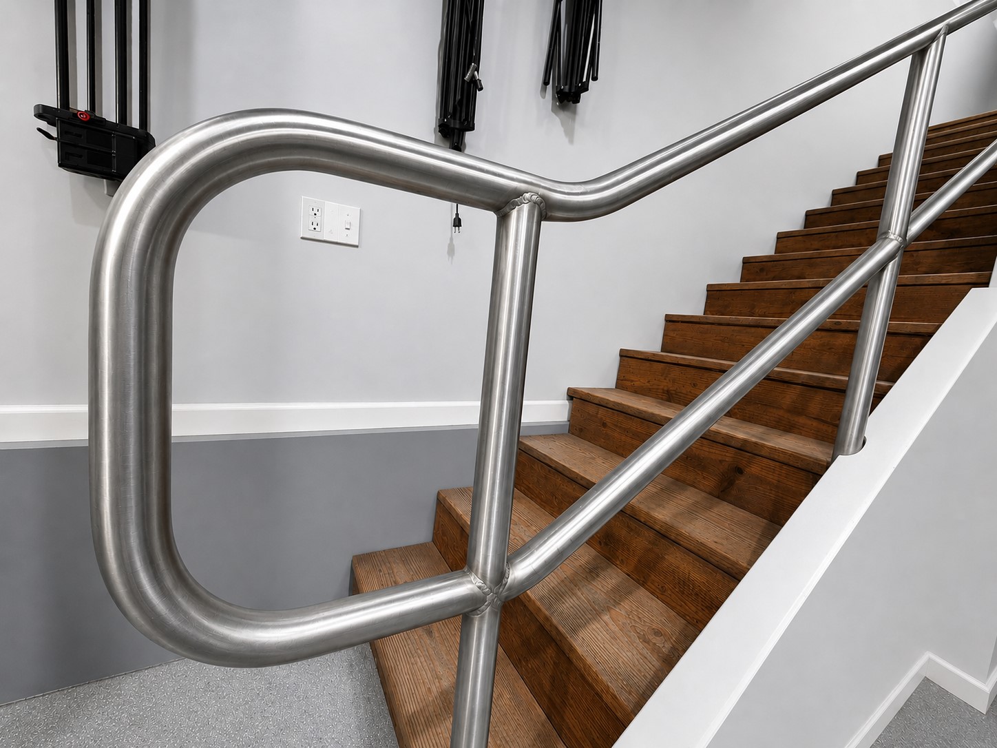 Installed stainless steel handrail with compound bends on staircase built by RogueFab Sandy Oregon